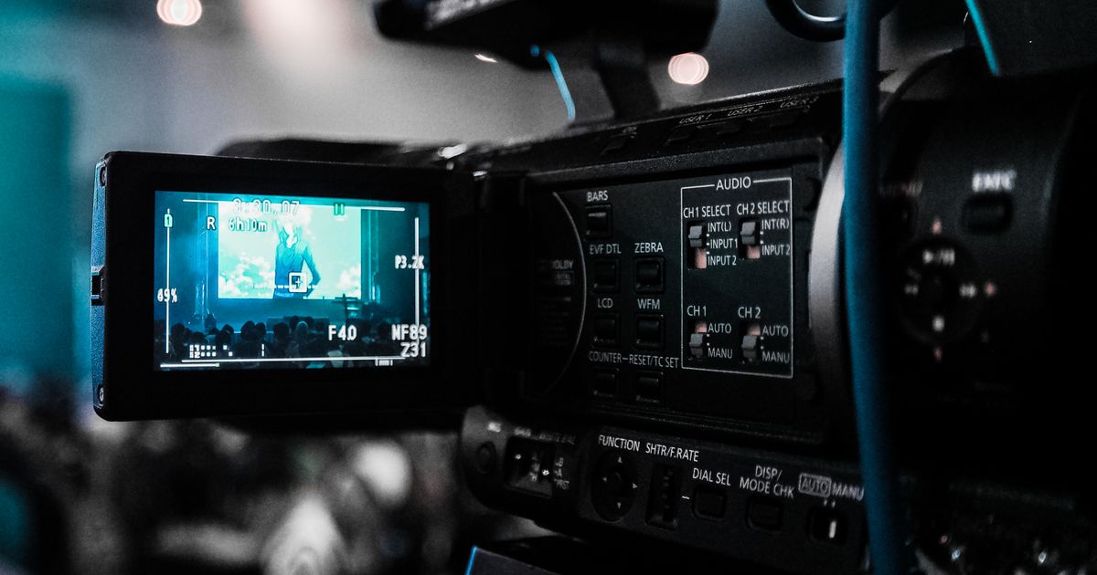 Bright modern daytime television talk-show studio set with cameras and warm lighting